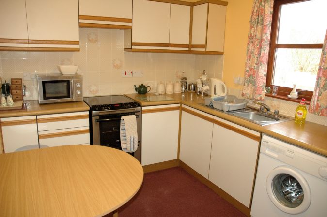 The kitchen in Tarlogie is well equipped with cupboards, work tops and appliances and also has a dining table and chairs.